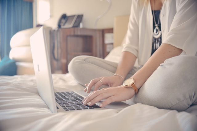 Žena koristi laptop na krevetu